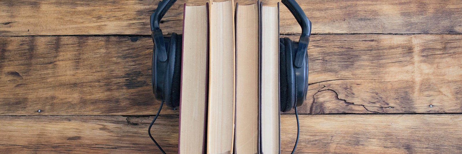 Headphones On The Pile Of Books On The Wooden Table. Audiobooks.